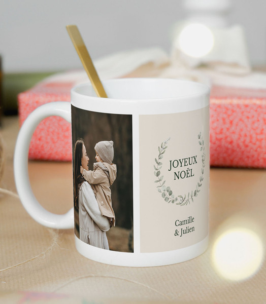 Mug en céramique blanche avec une couronne de Noël rouge et verte, deux photos d'enfants souriants et un texte "Joyeux Noël [Prénoms des enfants]".
